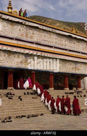 Linie der tibetischen Mönche Gebetshalle tragen weiße Schals in Labrang Kloster während eines Festivals, Xiahe eingeben. Stockfoto
