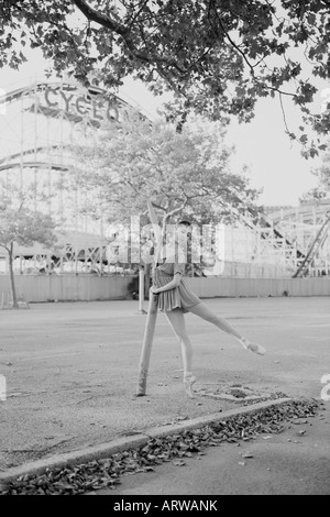 Ballerina tanzt auf einem leeren Parkplatz auf Coney Island mit dem Zyklon Steilabfall im Hintergrund Stockfoto