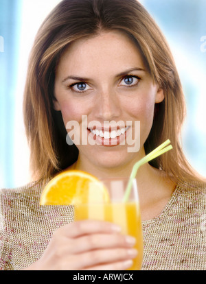 Eine Frau hält ein Glas Orangensaft mit Stroh Stockfoto