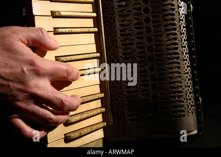 A mans Hand ein altes Akkordeon zu spielen. Stockfoto