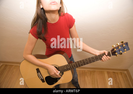 hispanischen Mädchen spielt akustische Gitarre und Gesang Stockfoto