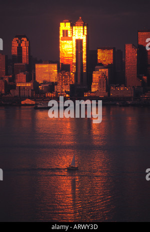 Blick über Elliot Bay von der Sonne von Gebäuden in der Innenstadt von Seattle Washington mit Segelboot im Wasser reflektiert Stockfoto