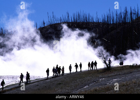 Touristen sind Silhouette gegen den Dampf aus einem geothermischen Gebiet im Yellowstone-Nationalpark, Wyoming Stockfoto