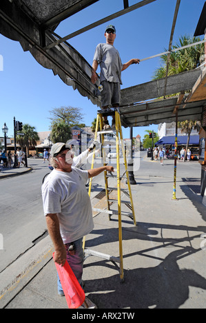 Menschen auf der obersten Stufe der Leiter, Reparaturen in Key West Florida Hotel Stockfoto
