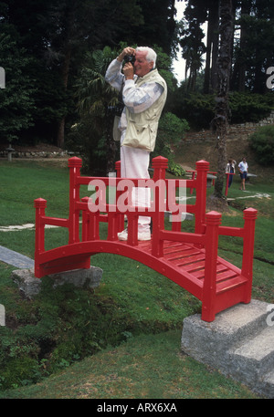 Touristen fotografieren aus der rote japanische Brücke in den spektakulären Gärten auf der viel besuchten Powerscourt Estate, Wicklow Stockfoto