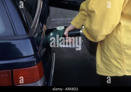 Weibliche Hand auf unverbleites Benzinpumpe platziert in Füllstoff für Auto Stockfoto