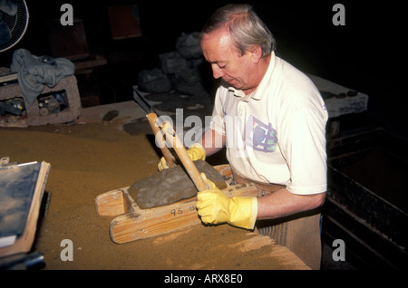 Die Ziegel von hand aus Ton, in eine Holzform gebracht und der überschüssige Ton wird mit einem Draht Bogen abgeschnitten Stockfoto