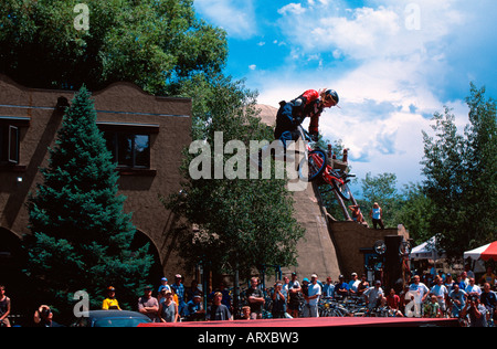 BMX-Fahrer springen und dabei einen Trick vor Publikum Stockfoto