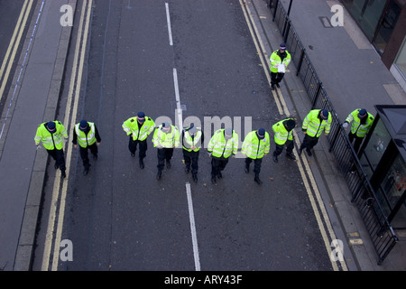 Dünne blaue Linien Polizisten in der Schlange auf der Suche nach Beweisen und Hinweisen auf Verbrechen, die in der City of London Street begangen wurden Stockfoto