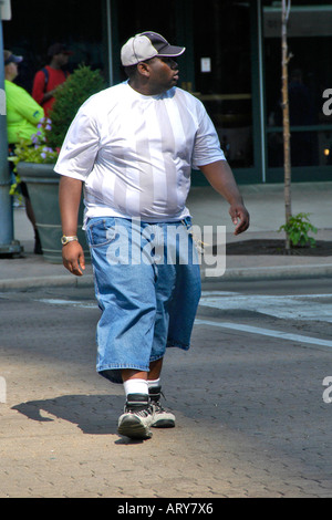 Übergewichtige Teenager schwarzer Rüde zu Fuß entlang einer Straße in der Innenstadt von Dayton Ohio. Stockfoto