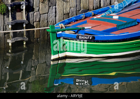 Vertäut bunten Boot im Hafen von Portsoy Banff mit Reflexion in noch Hafen Gewässern Schottland, Vereinigtes Königreich Stockfoto