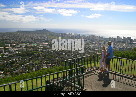 Ein junges Paar genießt diese Panaramic Aussicht auf Diamond Head und Skyline-Umgebung von Puu Ualakaa Park und Strecke. Stockfoto