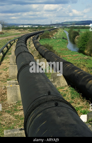 Rohrleitung vom Llanwern Stahlwerk läuft neben Entwässerungsgraben Entlastung ins Meer Newport Gwent Wales UK Ebenen Stockfoto