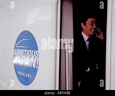 Ein japanischer Geschäftsmann reden auf seinem Handy stehen innerhalb der Shinkansen-Hochgeschwindigkeitszug Tokio Japan Stockfoto