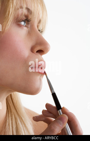 Profil von Frau Auftragen von Lippenstift Stockfoto