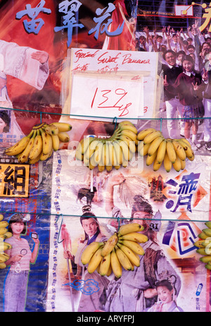 Apfel Bananen hängen auf dem Display an einen Lebensmittelmarkt Chinatown vor asiatische Poster, Honolulu Stockfoto