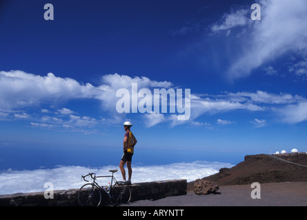 Biker, ruht auf Haleakala im Haleakala National Park bei 10.023 ft. Blick auf den Pazifischen Ozean und Wolken mit der Wissenschaft Stockfoto