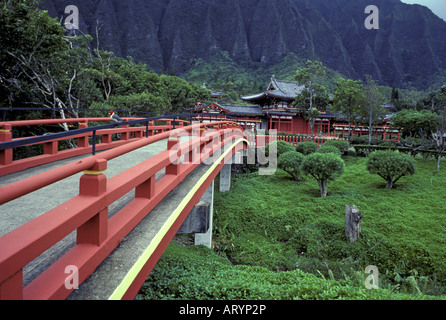 Lokalen Vogel Sitzstangen auf rote Brücke führt zum Byodo-in Tempel eingebettet gegen üppige Koolau Berge auf Oahu Windseite Stockfoto