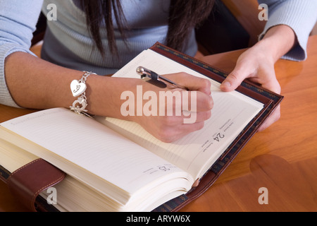 Junge Frau Terminvereinbarung. Hautnah an Händen und Tagebuch Stockfoto