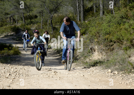 Frankreich Provence Vitrolles Young Boy und drei Erwachsene Reiten Mountainbikes auf einem Feldweg Stockfoto