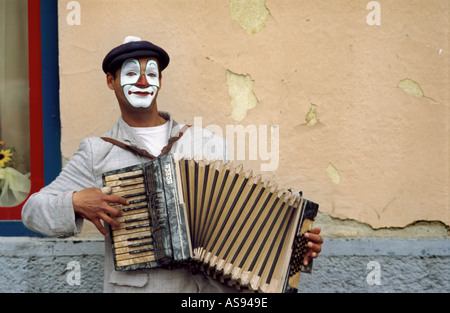 Straßenmusiker Hanswurst spielen Mundharmonika Stockfoto