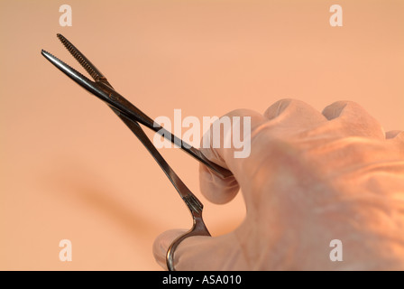 Hand hält ein paar chirurgische Pinzetten Stockfoto