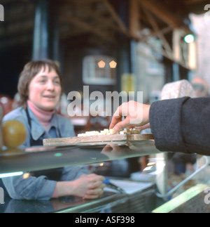 Ein Kunde probiert ein Stück von Trethowan Welsh Caerphilly Cheese Stall am Borough Market in London, England, UK, KATHY DEWITT Stockfoto