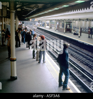 Passagiere warten auf einen Zug auf der Plattform in der High Street Kensington Station in West London UK KATHY DEWITT Stockfoto