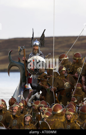 Jarl Roy Leask steht auf der Galeere Brecon in Rüstung mit seiner Mannschaft Stockfoto