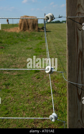 Elektrischer Zaun um einen Heuballen in einem ländlichen amerikanischen Feld, USA. Stockfoto