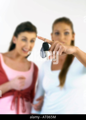 zwei junge Frauen, die Auto-Taste gedrückt halten Stockfoto