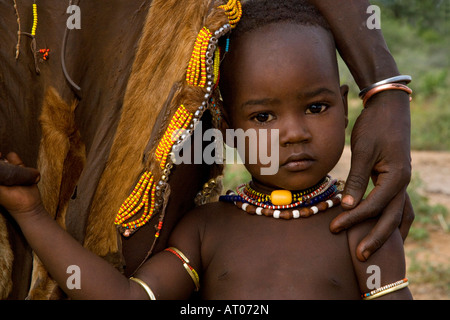 Wunderschönes schüchtern Mädchen von der Hamer Stamm hält sich an ihre Mutter, Omo River Valley, Äthiopien Stockfoto