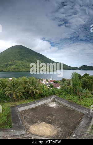 Indonesien, Bandanaira Township und Hafen von Fort Belgica mit dem Vulkan Gunung Api im Hintergrund betrachtet Stockfoto