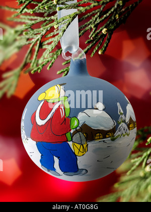 Traditionelle festlich geschmückte Weihnachtskugel, die an einem Weihnachtsbaum hängt Mit Licht dahinter Stockfoto