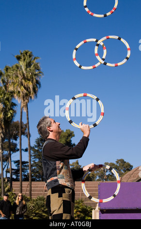 A Street Performer jongliert Creolen in einer schönen Parklandschaft. Stockfoto