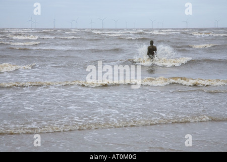 Antony Gormley Skulptur des Menschen Blick auf das Meer in Richtung Windenergieanlagen Crosby Strand Merseyside England UK GB Stockfoto
