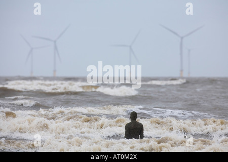 Antony Gormley Skulptur des Menschen Blick auf das Meer in Richtung Windenergieanlagen Crosby Strand Merseyside England UK GB Stockfoto