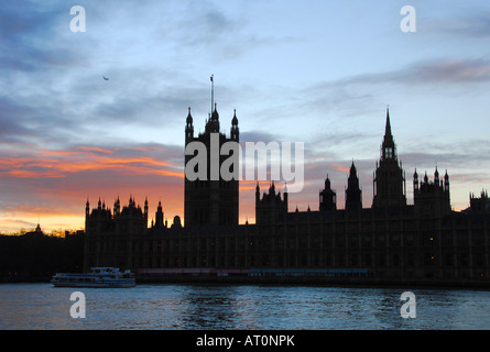 Die Sonne versinkt hinter dem Palast von Westminser (Houses of Parliament) in London Stockfoto