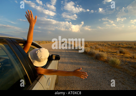 Eine Frau lehnt sich auf der Seite des Wagens in Heiterkeit, Kalifornien, USA Stockfoto