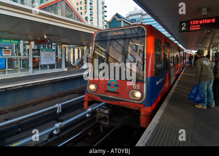 Horizontalen Weitwinkel der Docklands Light Railway Zug ziehen in South Quay Station mit Passagiere warten auf der Plattform Stockfoto