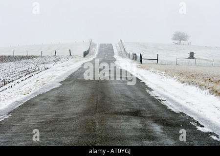 Landstraße durch Schnee bedeckt Felder Washington County Indiana Stockfoto