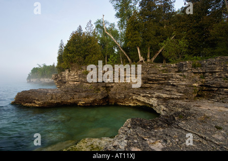 Felsklippen und nahenden Morgennebel am Lake Michigan-Höhle County Park Door County Wisconsin zeigen Stockfoto