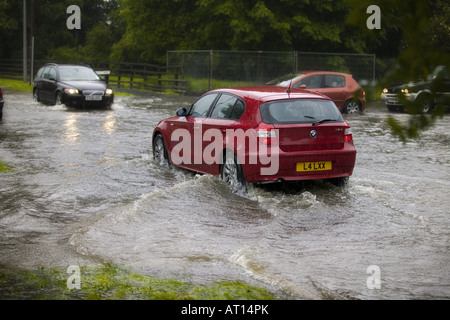 Überschwemmungen in Rumpf folgte ein Wochenende mit hohen Temperaturen in ganz Großbritannien, Autos, Wasser von der Straße drängen, in nahe gelegenen Gärten. Stockfoto