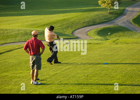 ILLINOIS Aurora erwachsenen männlichen Golfer auf Phillips Park Golfplatz Mann geschwungen Golfclub am Abschlag Blick auf Fairway Wagen Weg Stockfoto