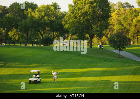 ILLINOIS Aurora erwachsenen männlichen Golfer auf Phillips Park Golfplatz Mann geschwungen Golfclub Fairway Golf-Cart unterwegs Stockfoto