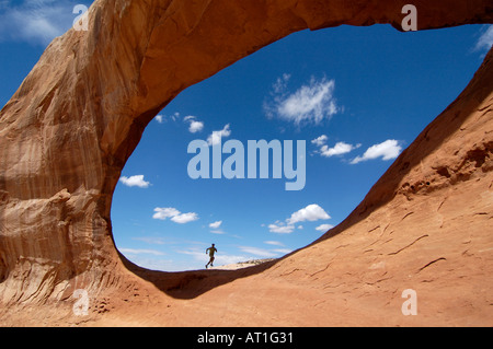 Mann läuft durch Wilson Arch, Utah, USA Stockfoto