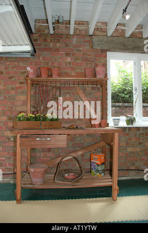 Terrakotta-Töpfe und Gartengeräten auf Holzregalen in garage Stockfoto