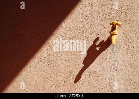 Wasserhahn an der Wand auf Schatten Stockfoto