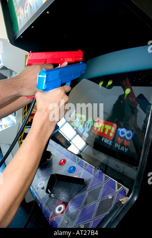 Teenager shooting Point Blank video Game mit roten und blauen Replik 45 Kunststoff Pistolen Kaliber. St Paul Minnesota MN USA Stockfoto