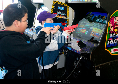 Kinder Alter 11 shooting Point Blank Videospiel mit roten und blauen Replik 45 Kaliber Pistolen. St Paul Minnesota MN USA Stockfoto